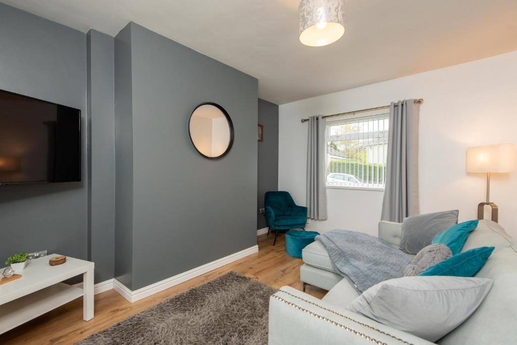 a living room with a couch and a mirror at The Crescent in Witton Gilbert