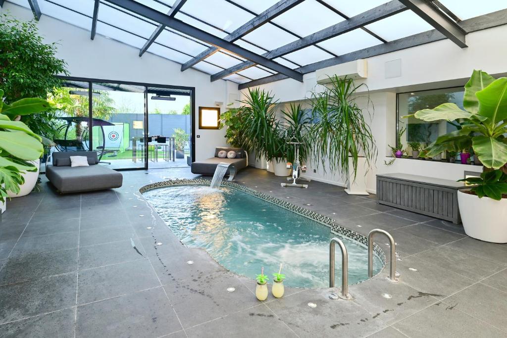 a swimming pool in a house with a glass ceiling at Le Loft Oasis Prestige - Piscine et jacuzzi in Pringy