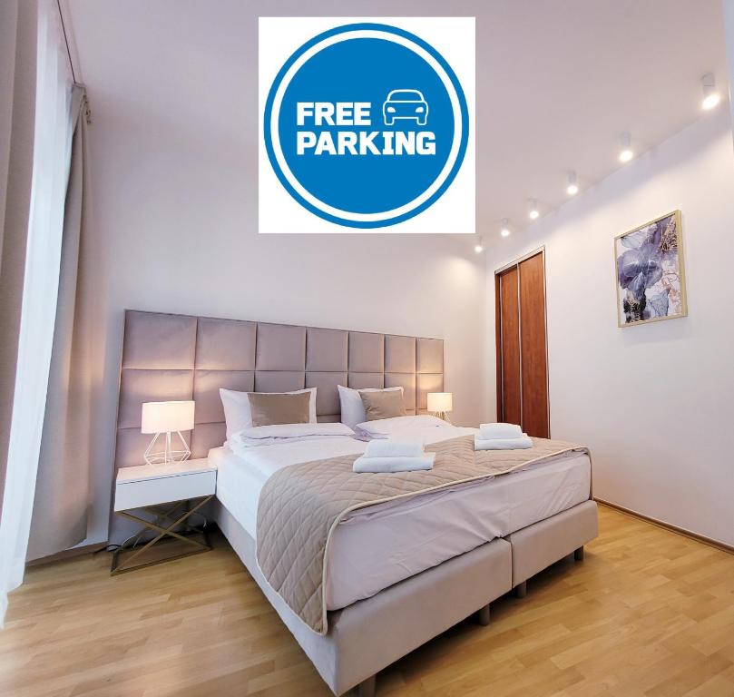 sypialnia z dużym łóżkiem z bezpłatnym znakiem parkingowym w obiekcie NOOK NOOK Apartments Kazimierza Wielkiego 104 w Krakowie