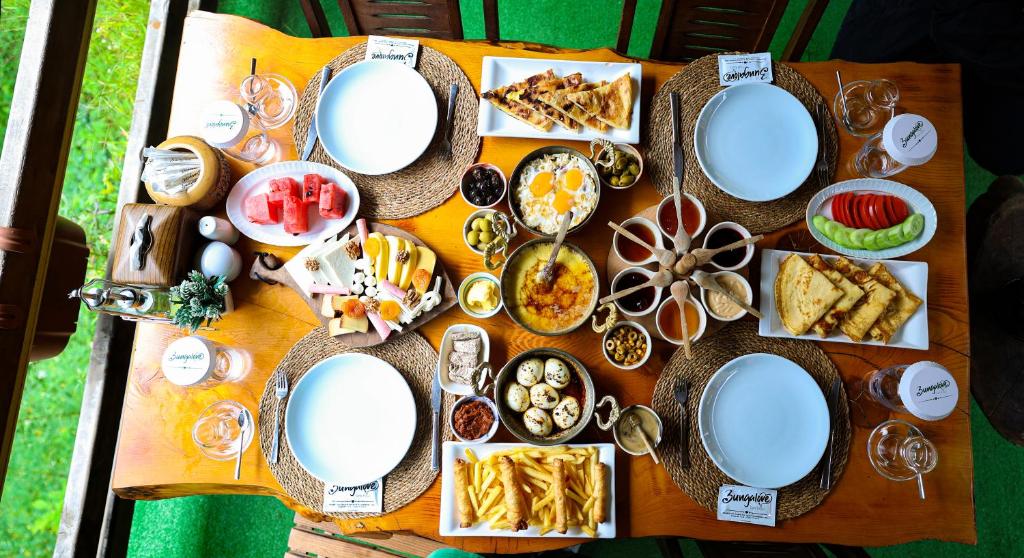 una mesa con platos de comida encima en bungalove tatil köyü, en Çamlıhemşin