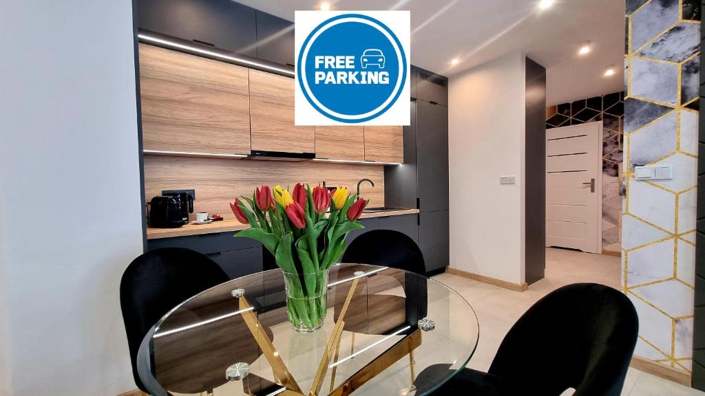 a dining room with a glass table with flowers on it at NOOK NOOK Apartments Bytkowska 103 in Katowice