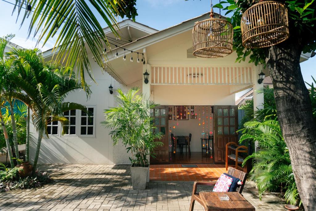 a house with a palm tree and a patio at Baan Ragang : Cozy Entire House in Old Chiang Mai in Chiang Mai