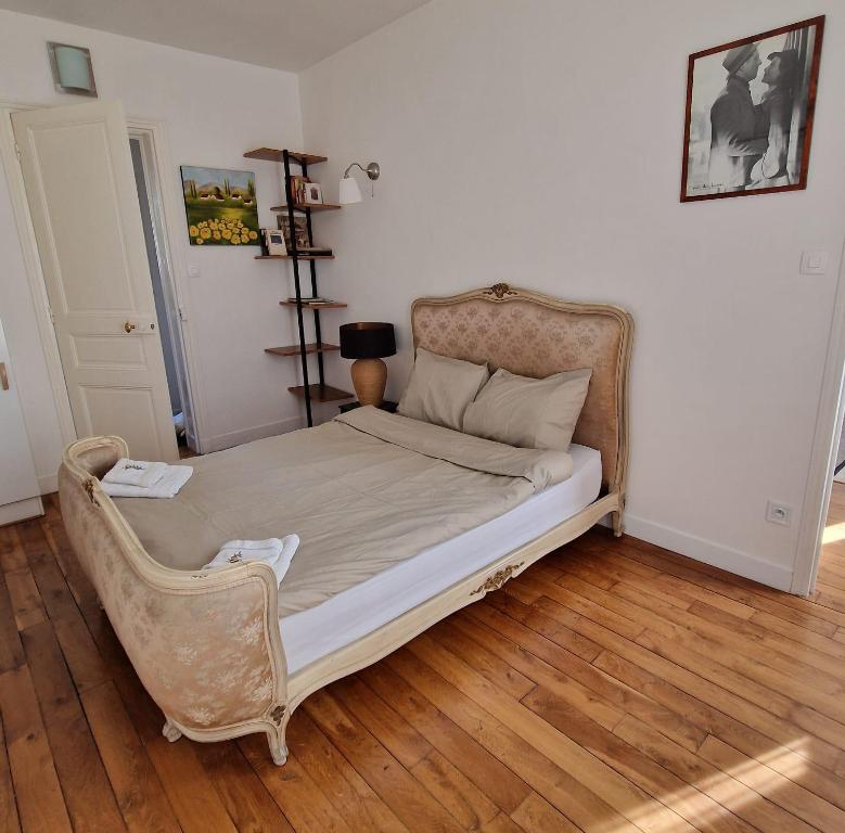 a bedroom with a bed with a chair in it at Appartement SAINTE ELISABETH - République in Paris