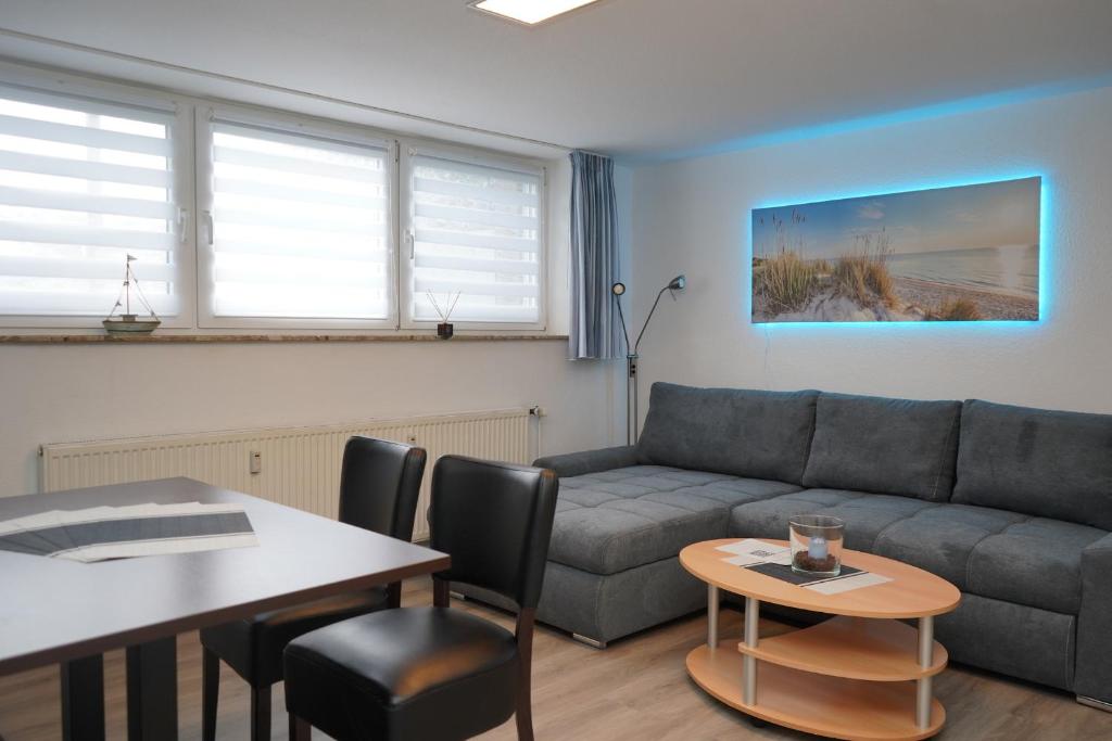 uma sala de estar com um sofá e uma mesa em Yildirim Touristik Wohnung L&L 7 em Duhnen