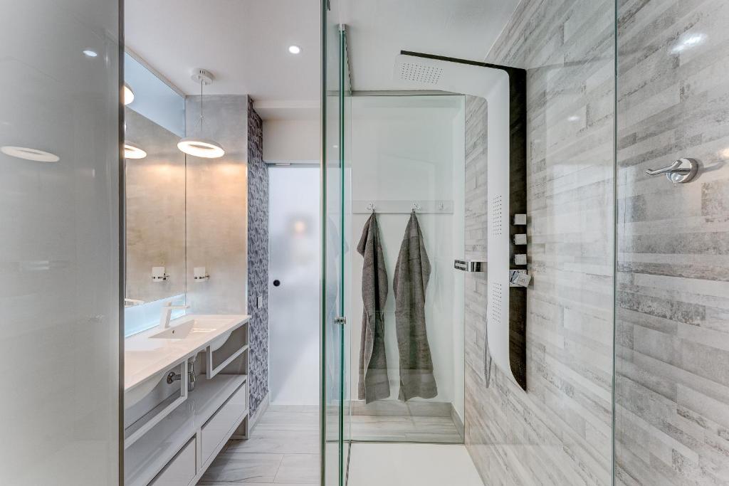 a bathroom with a glass shower and a sink at BAL Apartments Adults Only in Arona