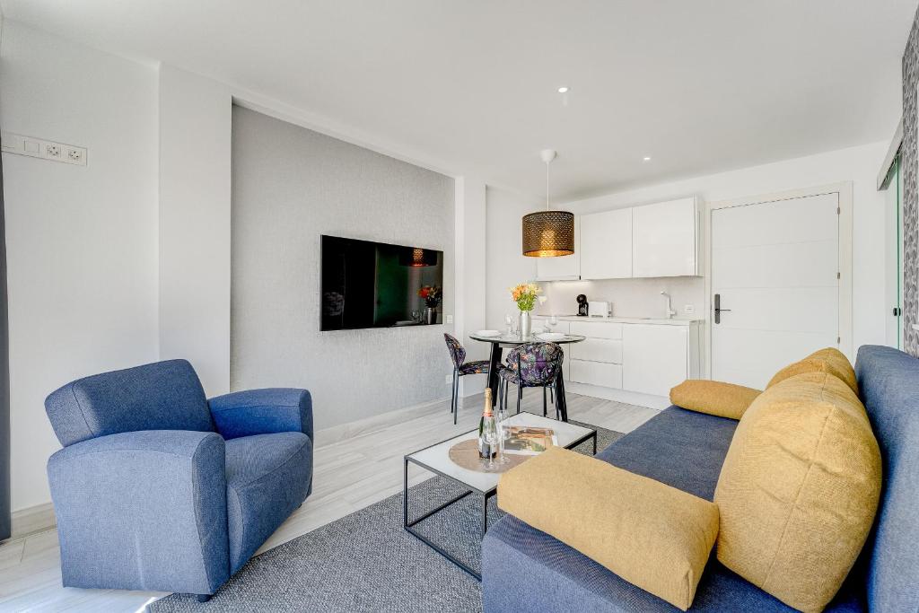 a living room with two blue chairs and a table at BAL Apartments Adults Only in Arona