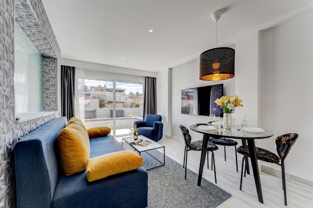 a living room with a blue couch and a table at BAL Apartments Adults Only in Arona