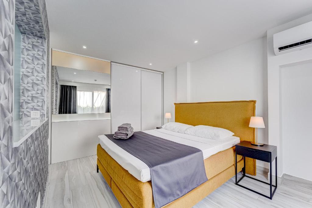 a bedroom with a large bed and a bathroom at BAL Apartments Adults Only in Arona