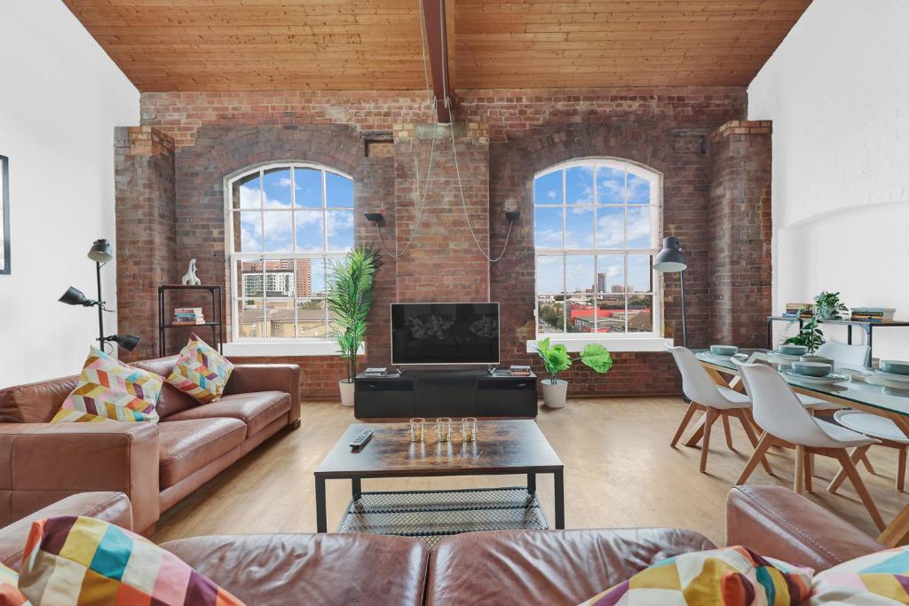 a living room with a couch and a table at Large Industrial Style 2 Bedroom Flat! in London