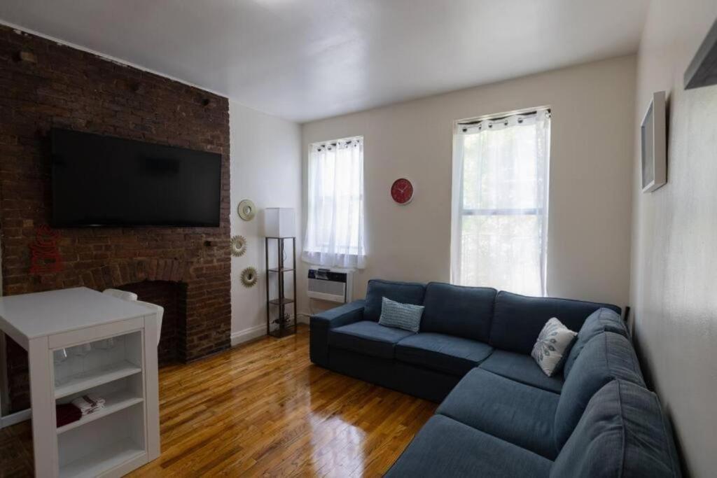 a living room with a blue couch and a fireplace at Warm 1-Bedroom Apt in Manhattan in New York