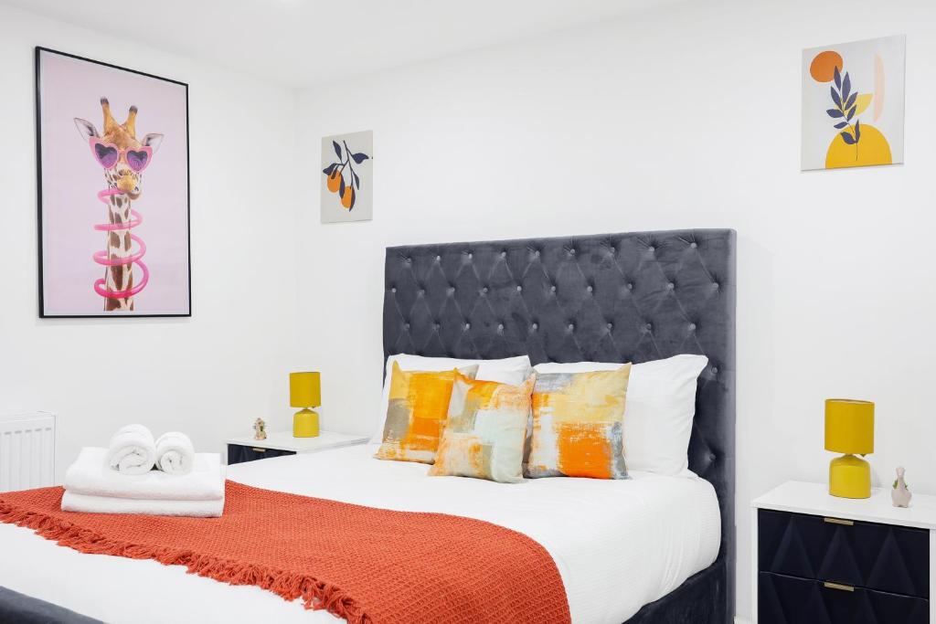a bedroom with a bed with orange and yellow pillows at Cool 2 Bed Basement Flat in Central Shoreditch! in London
