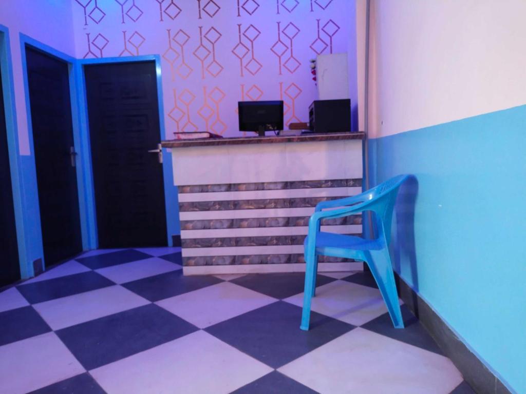 einen blauen Stuhl in einem Zimmer mit kariertem Boden in der Unterkunft OYO Blue Dream Palace in Nārnaul