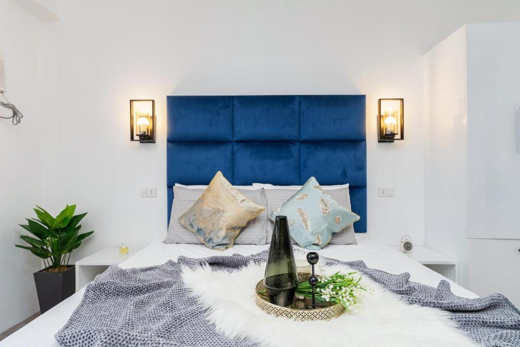 a bed with a blue headboard and a bottle of wine at Kalani by J&J (Symfoni Nichols. Pool. Netflix) in Cebu City