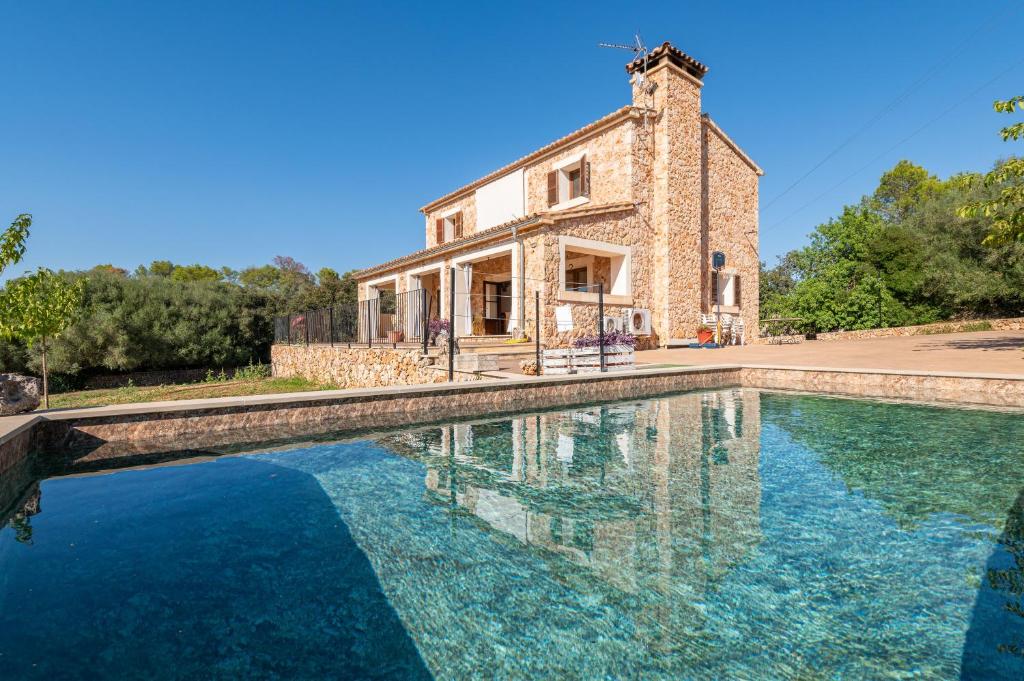 a house with a pool in front of a building at Ca Na Capellana in Sineu