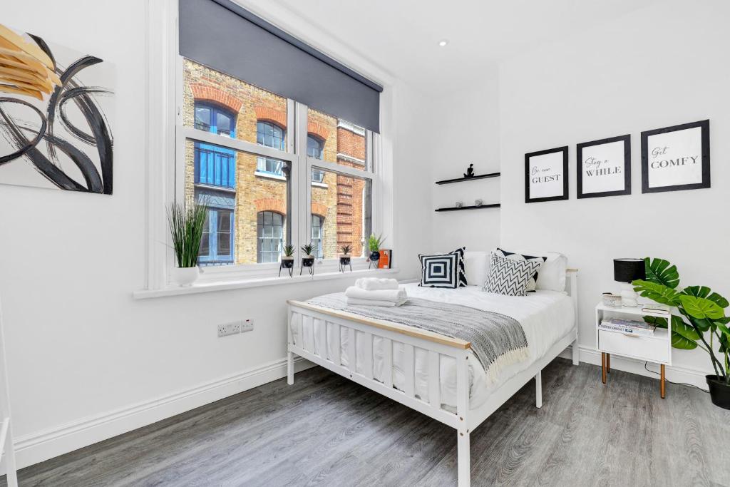 a white bedroom with a bed and a window at Central Hoxton High Spec 2 Bed! in London
