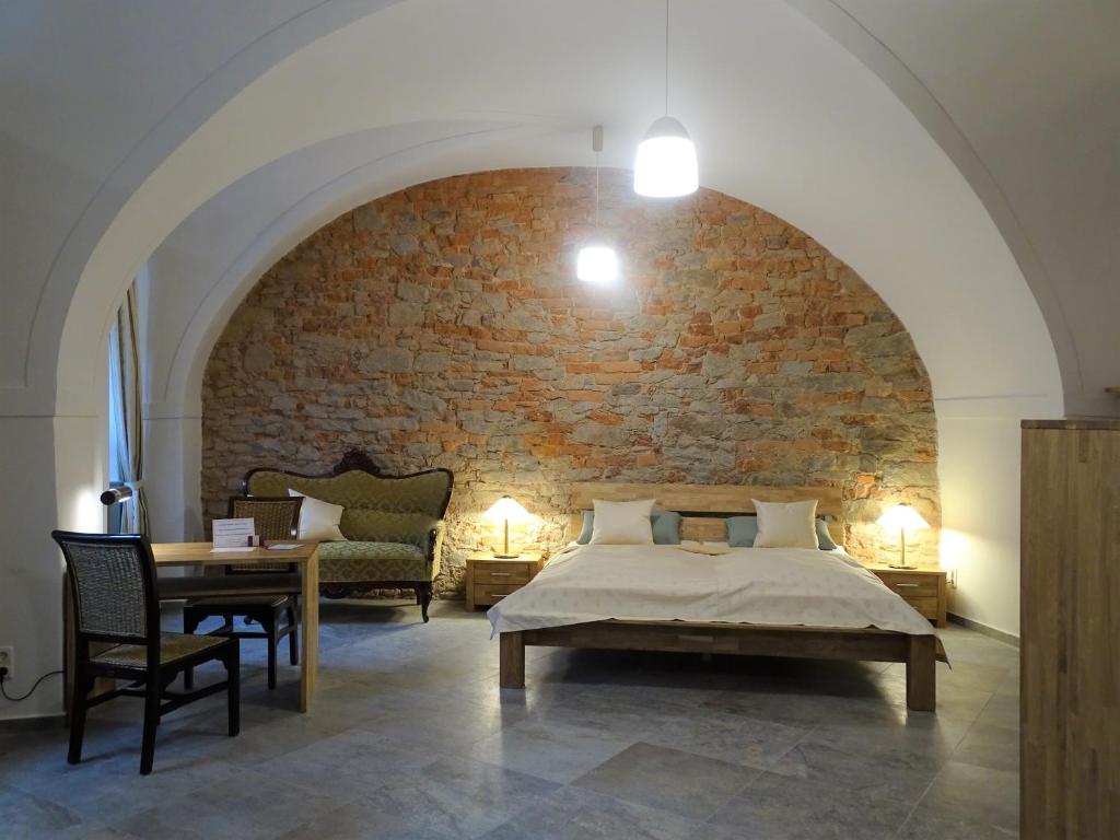 a bedroom with a bed and a brick wall at Stadtpalais Merkur-Apartment maximal 2 Personen in Bautzen