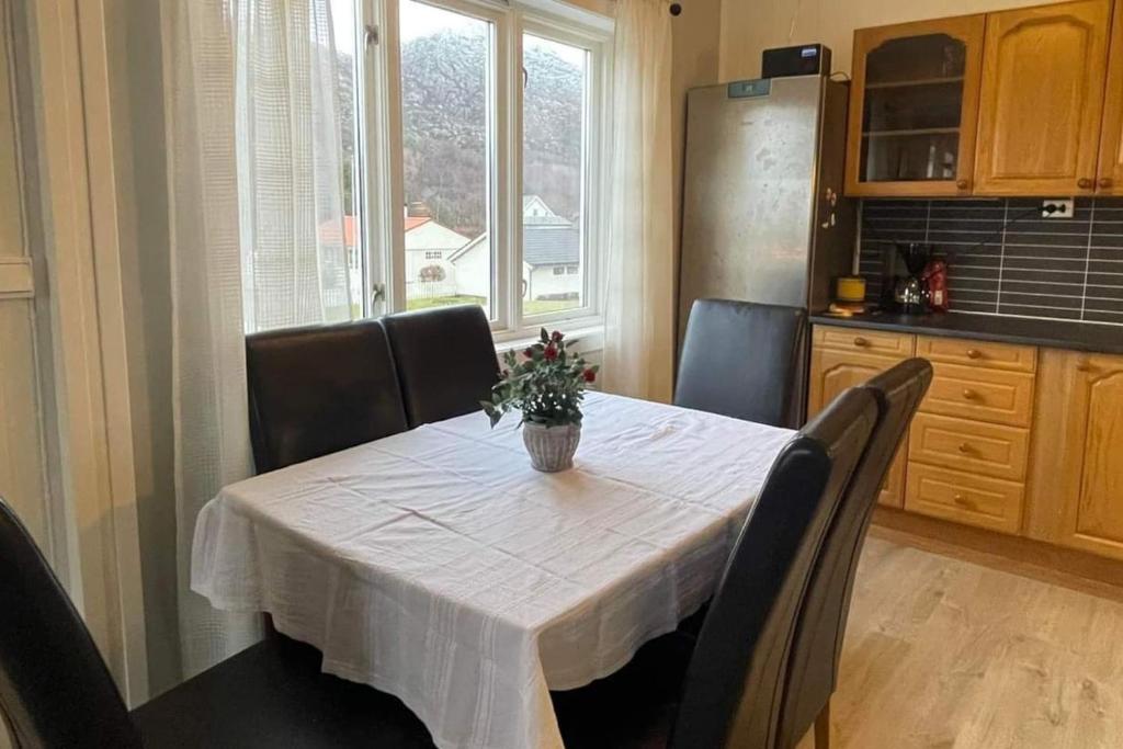 a kitchen with a table with chairs and a white table cloth at Leitane 2 Bremanger in Fossane