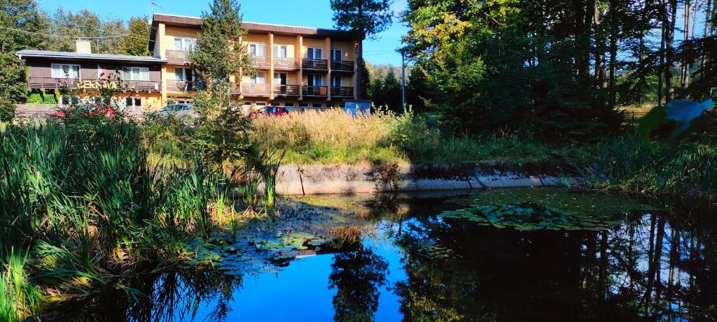 a building next to a body of water at Penzion Tesák-ČERŇAVA in Chvalčov