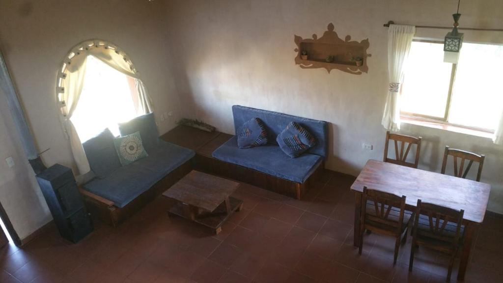ein Wohnzimmer mit einem blauen Sofa und einem Tisch in der Unterkunft Casa Amanecer in Samaipata