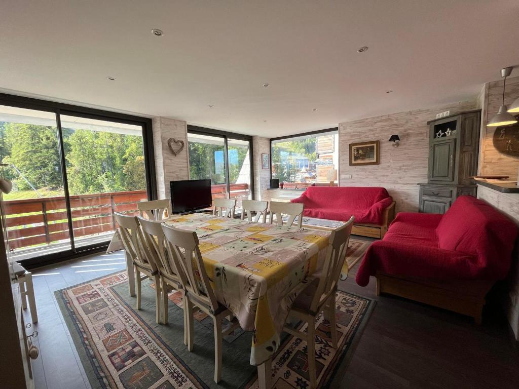 une salle à manger avec une table et des chaises rouges dans l'établissement Grand T4 rénové, 90m², Pra Loup 1600, 8 pers, près des pistes, balcon et box à skis - FR-1-165A-76, à Uvernet