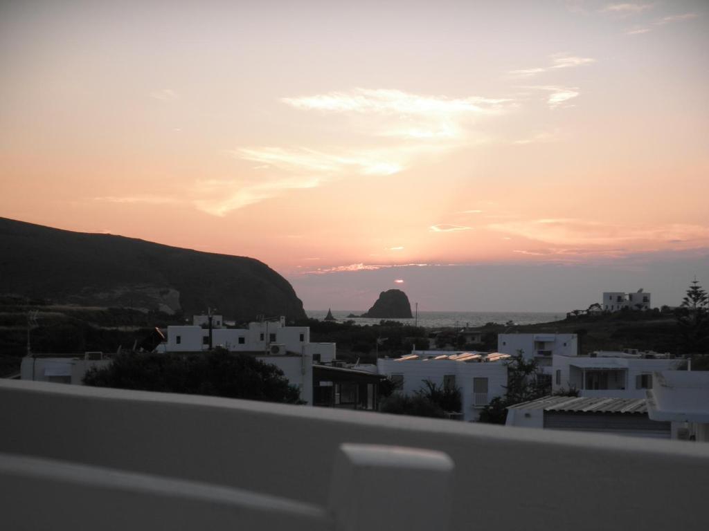 a sunset over a city with white buildings at Korina's Rooms in Pollonia