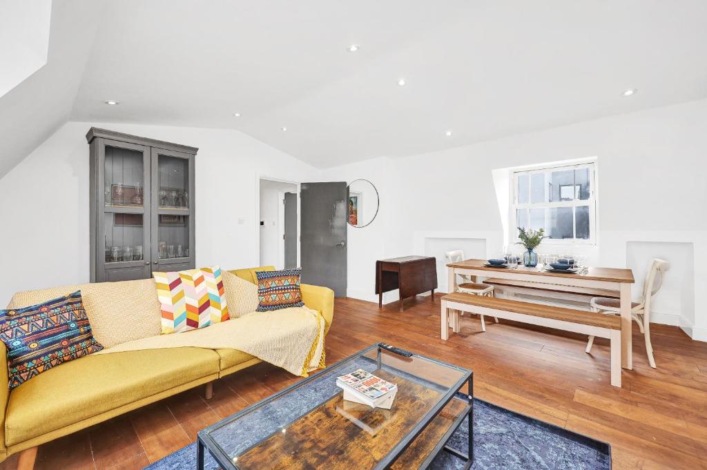 a living room with a couch and a table at Loft apartment in Broadway Market in London