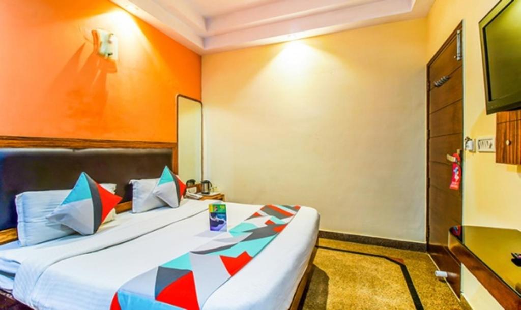 Habitación de hotel con cama y TV en FabExpress JP Palace en Nueva Delhi