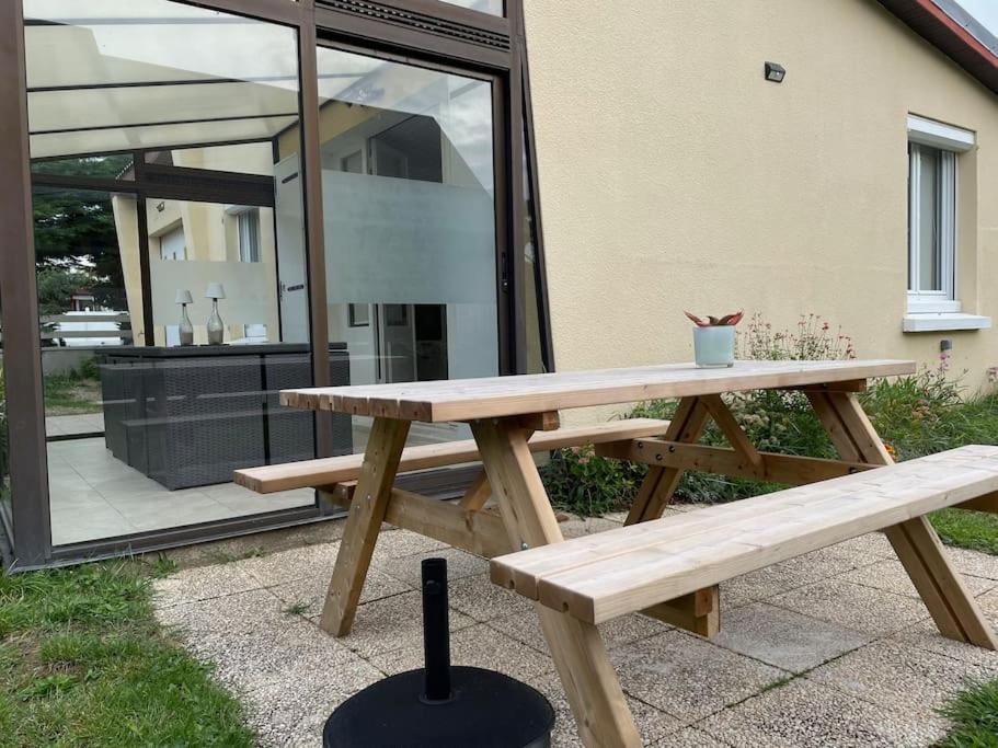 einem Picknicktisch aus Holz vor einem Haus in der Unterkunft Maison de la Mer in Saint-Germain-sur-Ay