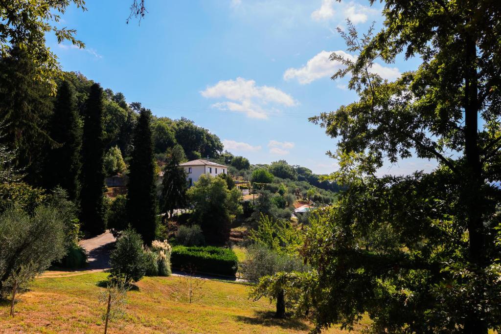 vistas a un jardín con árboles y a una casa en AGRITURISMO TERRA VOLONTERI, en Montecatini Terme