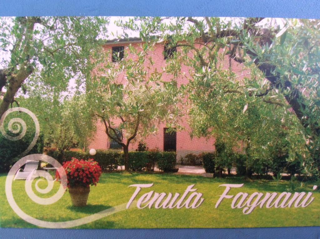 una casa rosa con un cartello davanti di Tenuta Fagnani a Lucca