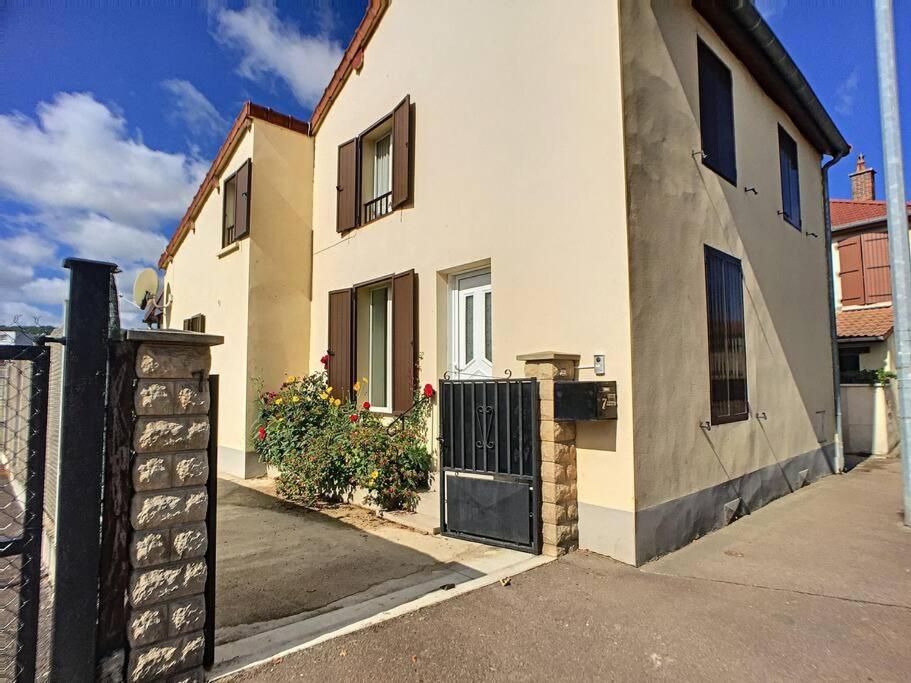 una casa blanca con una puerta y una valla en L'hirondelle du faubourg en Bar-sur-Aube