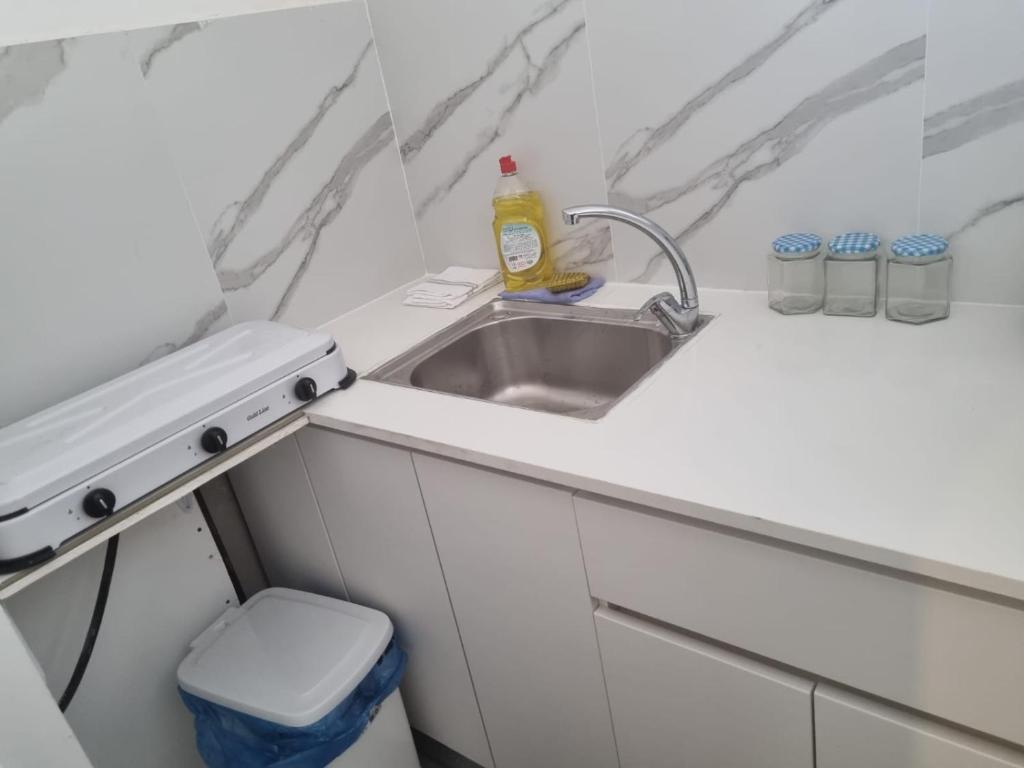 een witte keuken met een wastafel en een toilet bij בובה של דירה in Eilat