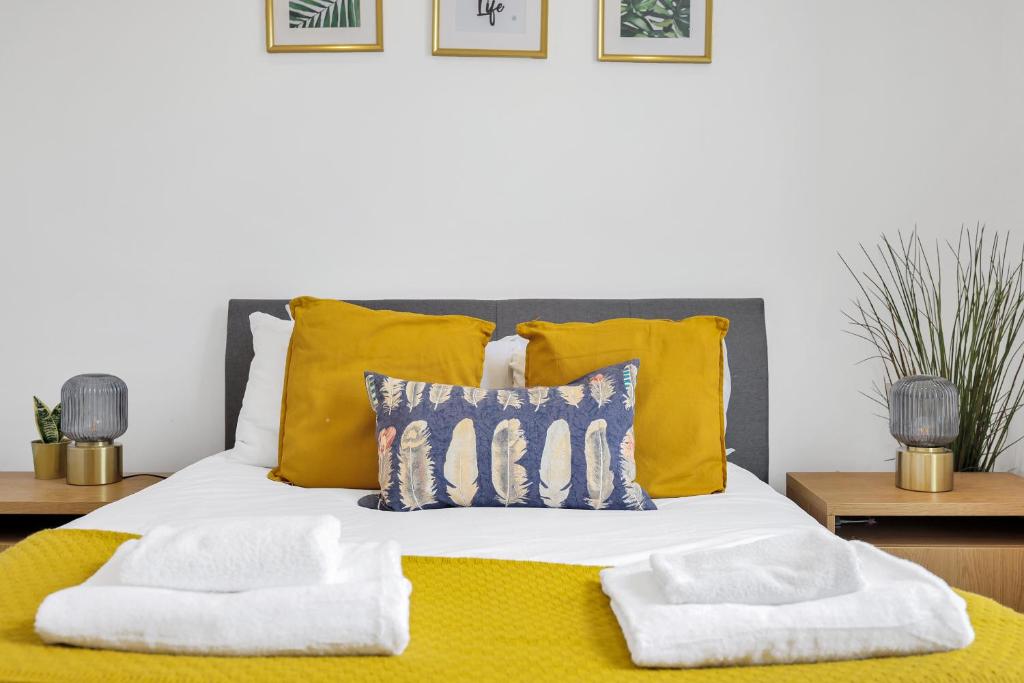 a bedroom with a bed with yellow pillows at New 1 Bedroom flat right on Broadway Market! in London