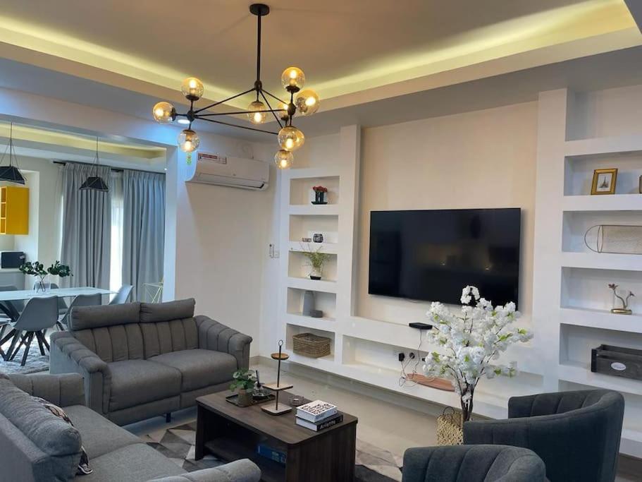 Il comprend un salon avec des canapés et une télévision à écran plat. dans l'établissement Modern 2 bedroom apartment in Sakumono-Tema Beach Rd, Accra-Ghana, à Accra