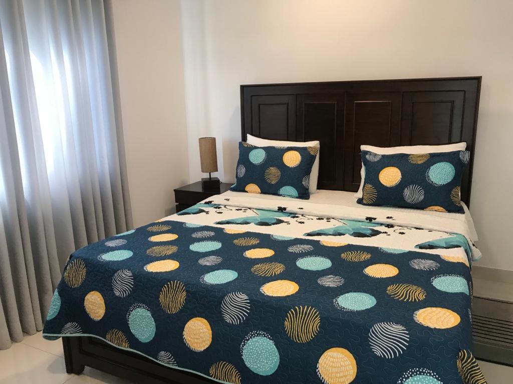 - une chambre avec un lit doté d'une couette bleue et jaune dans l'établissement Cozy apartment Battaramulla, à Colombo