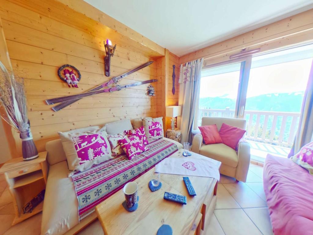 Appartement 3 pièces 8 pers Les Saisies avec Balcon - FR-1-594-40 في Villard-sur-Doron: غرفة معيشة بها سرير وأريكة