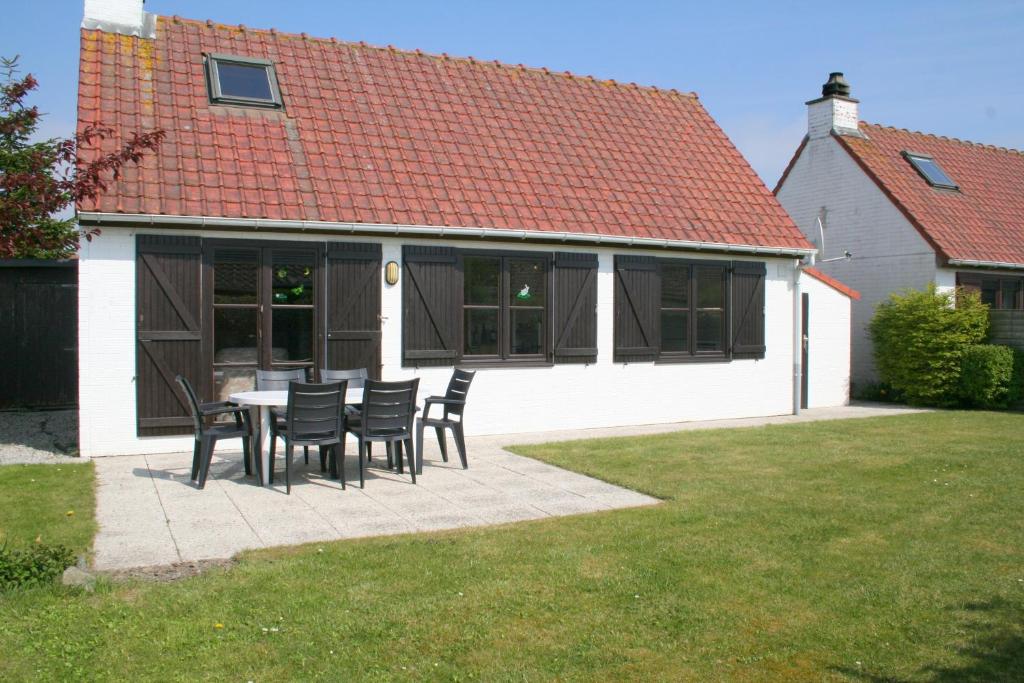 eine Terrasse mit Stühlen und einem Tisch vor einem Haus in der Unterkunft Zeewind II 278 in Bredene