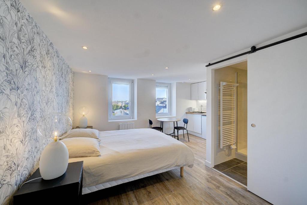 um quarto com uma cama grande e uma cozinha em L'Espadon - Appart'Escale em Saint-Nazaire