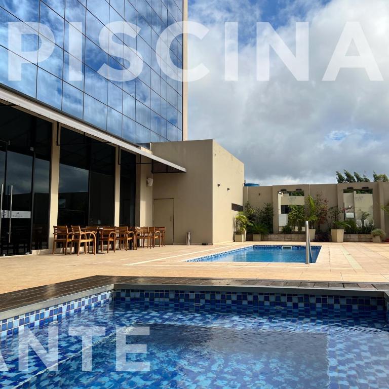 a swimming pool in front of a building at Carnaval Hotel Casino in Encarnación