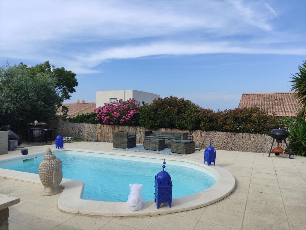 una piscina con jarrones azules alrededor en Villa 47 en Biguglia