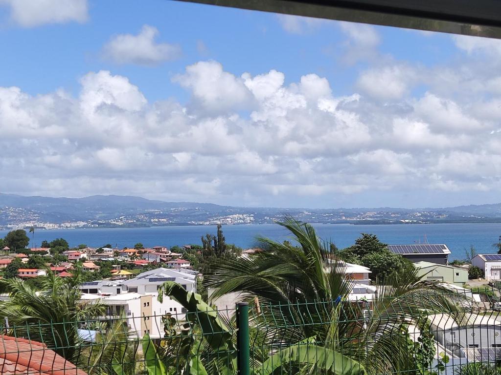 a view of a city with the ocean and buildings at Kazpucins T2 vue mer et pitons in Les Trois-Îlets