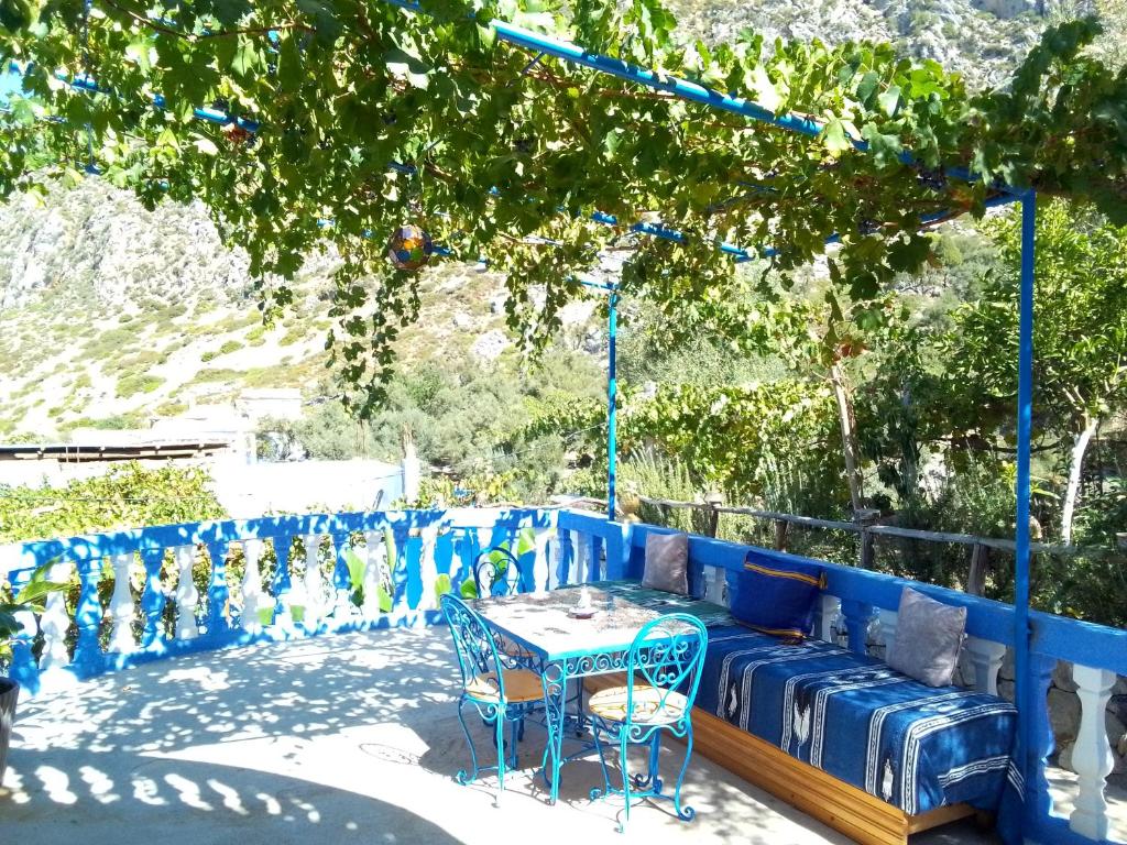 un banco azul con una mesa y sillas bajo un árbol en Blue House Town en Chefchaouene