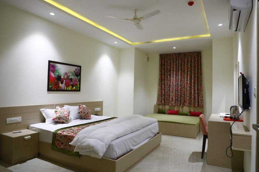 Hotel Grand Vasaante في Bhīlwāra: غرفة نوم بسرير كبير ونافذة
