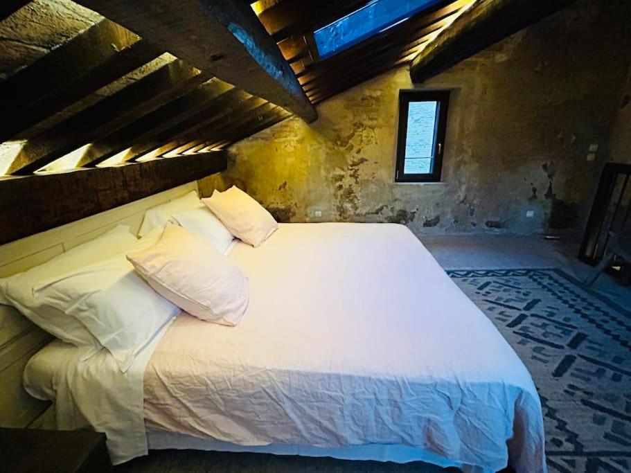a bedroom with a large bed with white sheets and pillows at "PALAZZO SABBIONI" Romantic Apartment with Kitchen Park View in Ferrara