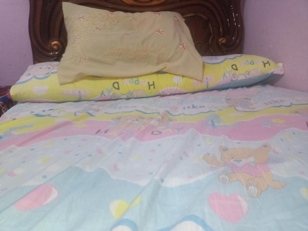 uma cama para crianças com um urso de peluche e uma almofada em HOSTEL em Cidade 6 de Outubro