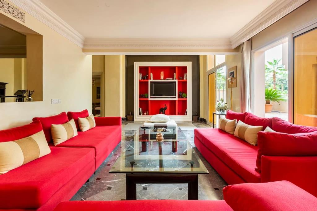 ein Wohnzimmer mit roten Möbeln und einem roten Sofa in der Unterkunft Somptueux Duplex au coeur de l'Hivernage in Marrakesch