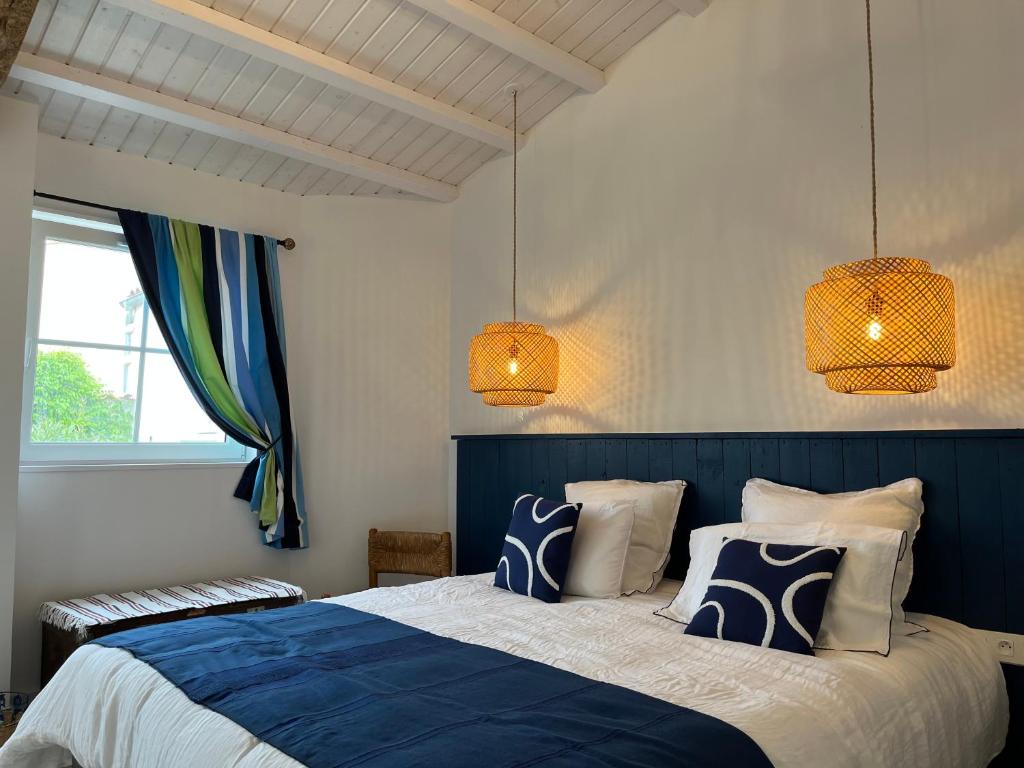 a bedroom with a blue and white bed and two lights at LE CLOS DE FLO 17 in Saint-Rogatien