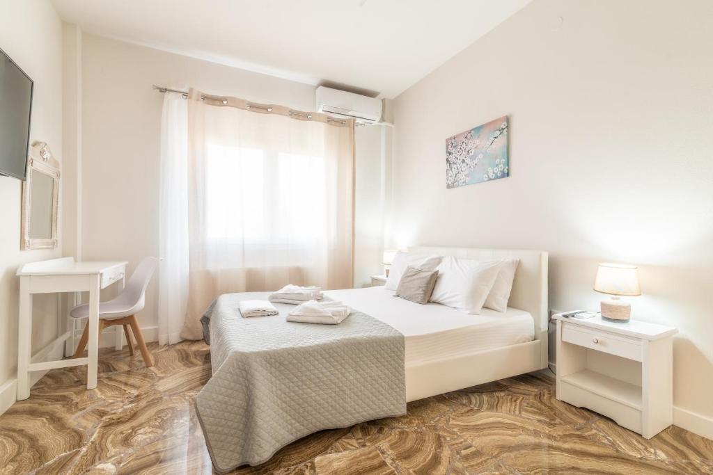 a white bedroom with a bed and a desk at Studio for Couples near Beach in Gázion