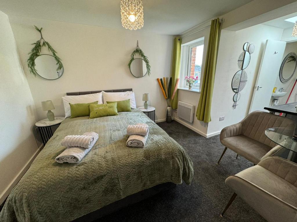 a bedroom with a bed and a chair and mirrors at Luxury Studio Stevenage in Stevenage