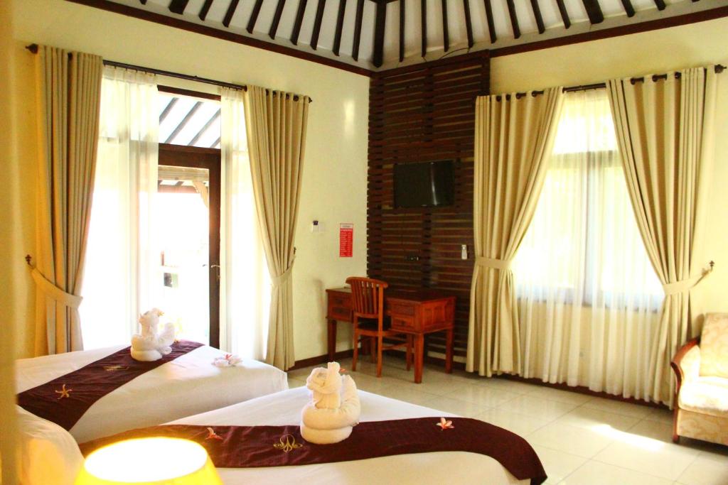 Postel nebo postele na pokoji v ubytování Taman Surgawi Resort & Spa